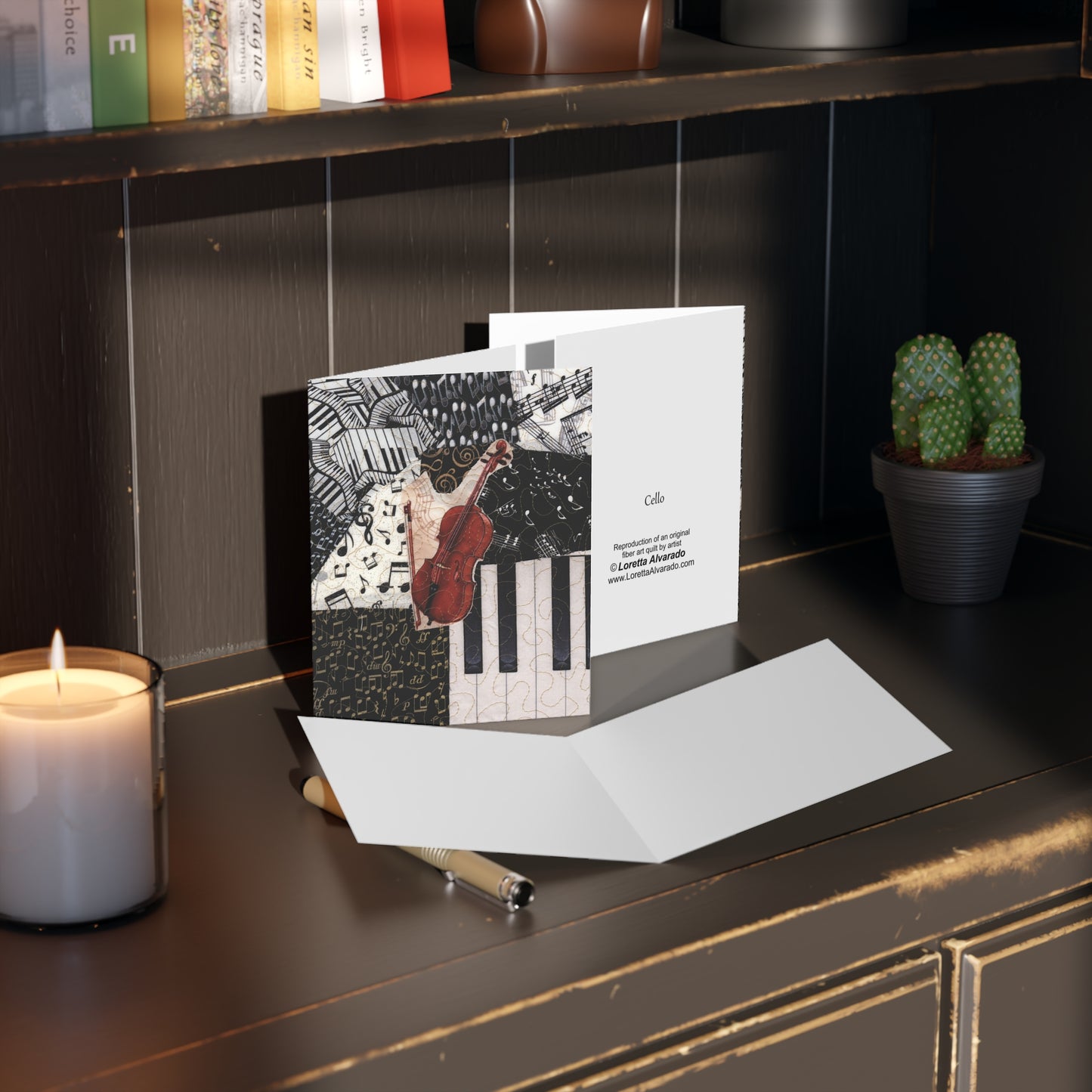 Greeting card with a cello design on a dark surface with a candle and plant