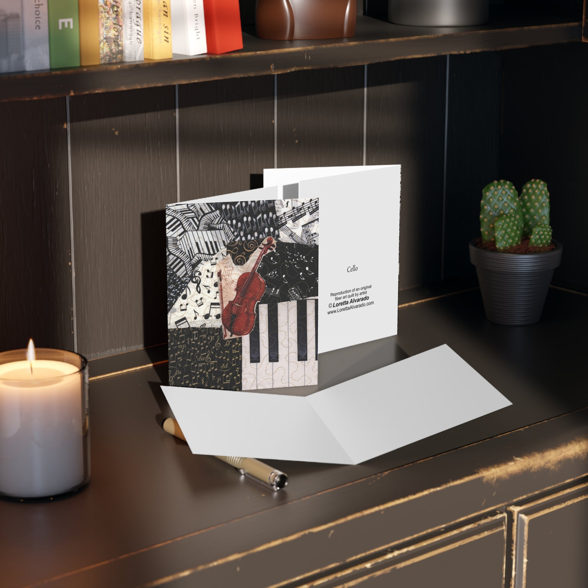 Greeting card with a cello design on a dark surface with a candle and plant