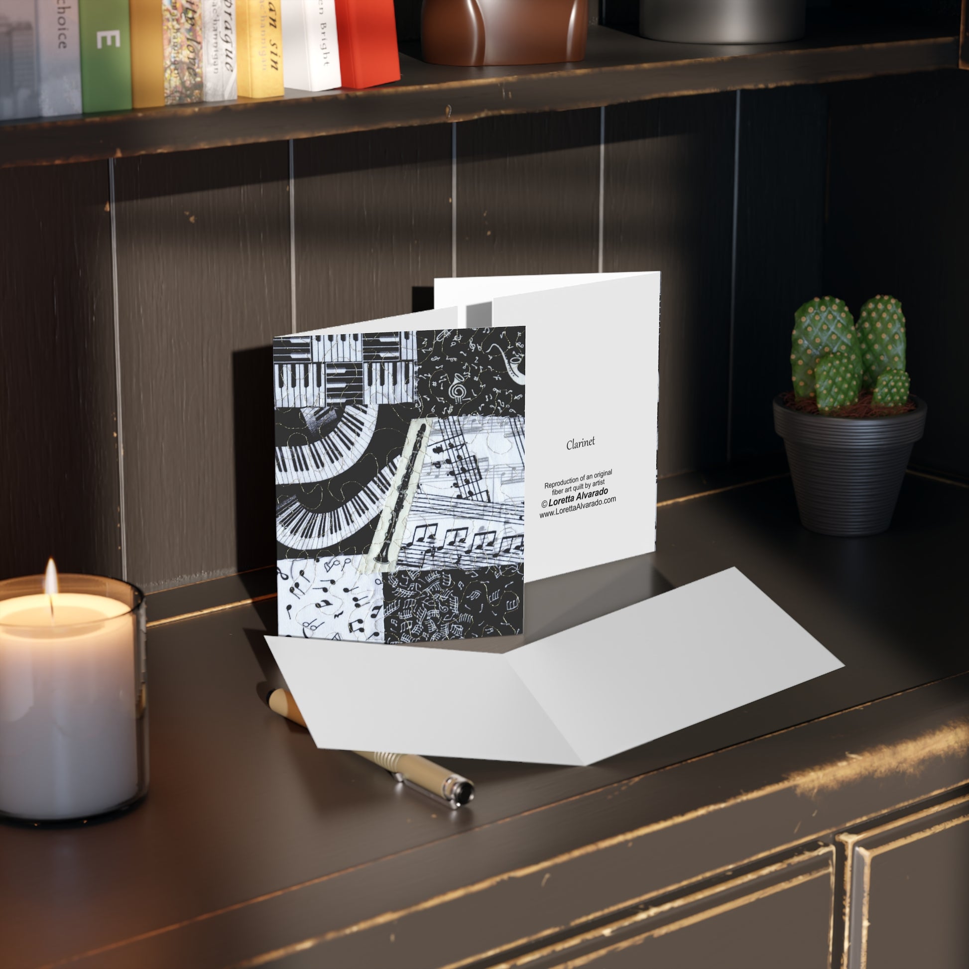 Greeting card with clarinet musical design on a dark surface with a candle and plant.